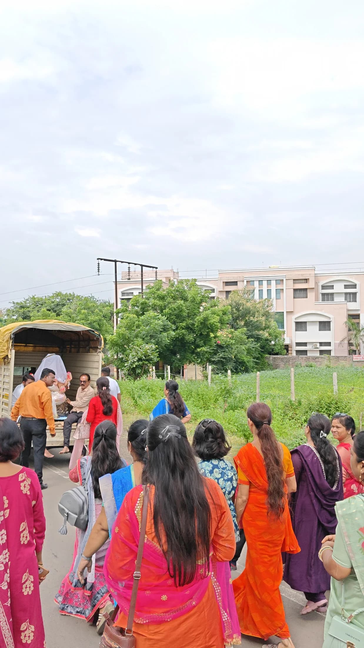 Students walking with saffron flags during the Ganpati arrival procession
