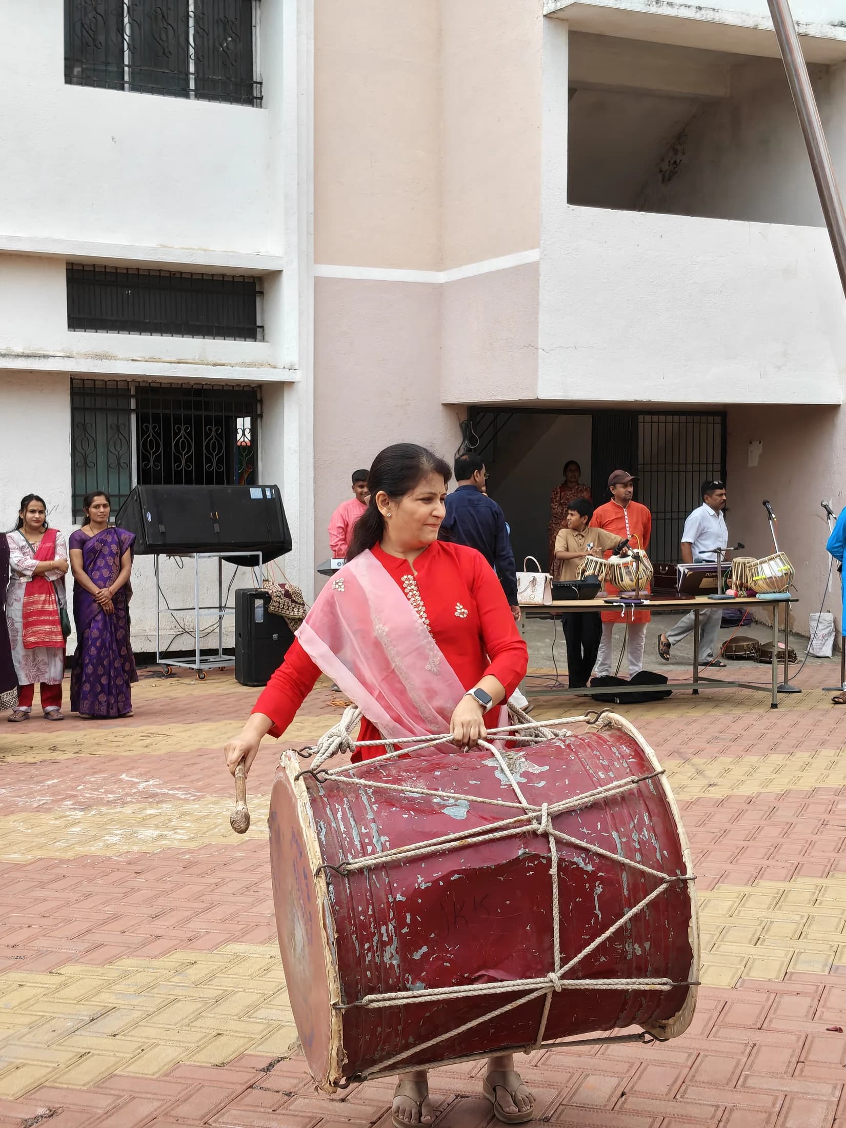 Student performing with dhol in the school ground during Ganesha Week