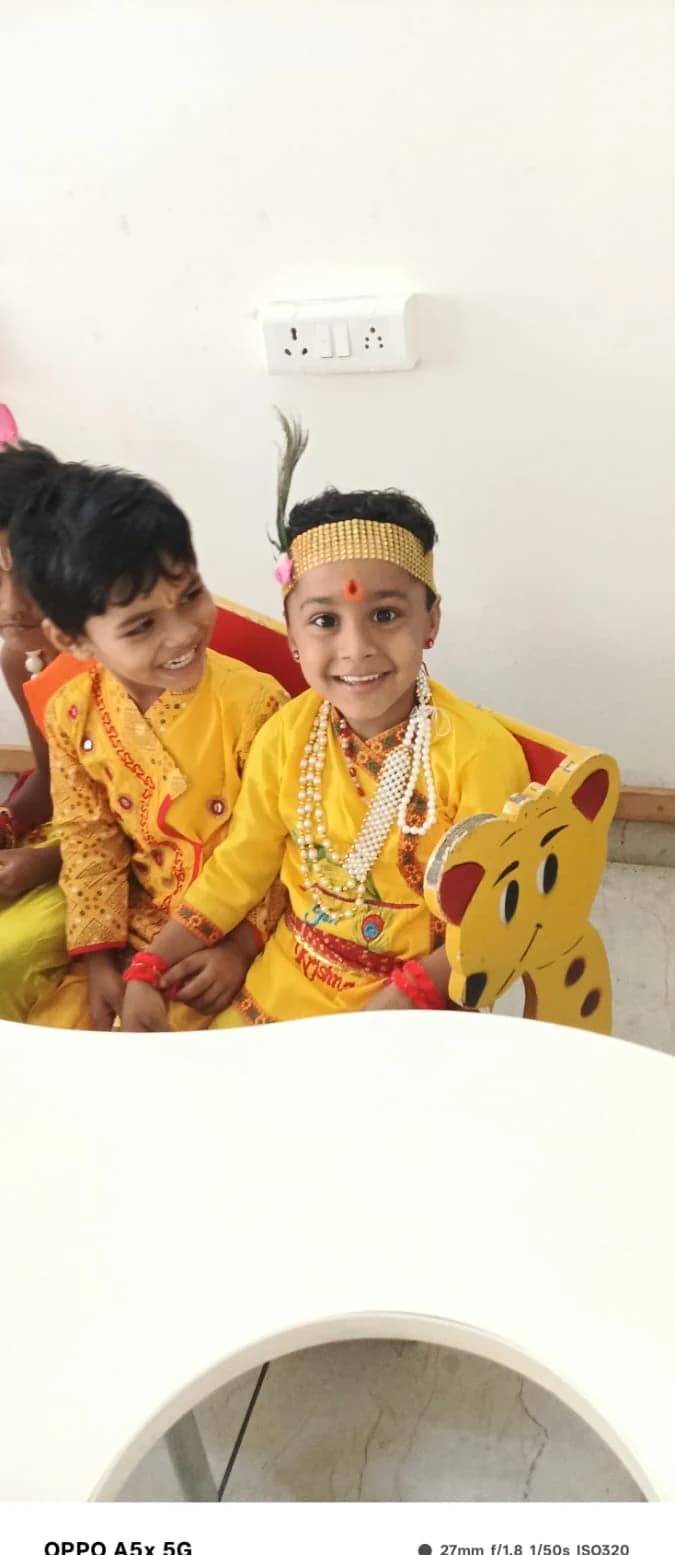 Young student smiling in yellow Krishna attire